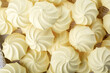 © geshas - French meringue cookies, yellow twisted crispy meringue as background.