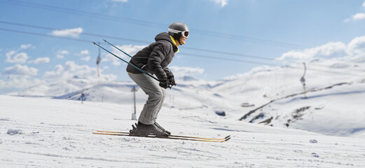 Canvas Print - Profile shot of a man skiing in a ski resort