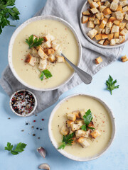 Wall Mural - cauliflower potato soup puree on blue tabletop, Creamy cauliflower soup with toasted bread croutons. Vegetarian healthy food concept. Ideas and recipes for winter meal. Top view or flat lay