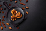 Fototapeta Sawanna - Sweet tasty tart with nuts and honey on a dark concrete background