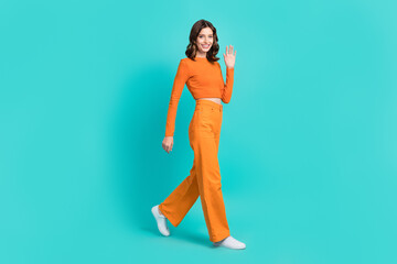 Wall Mural - Full length photo of positive adorable lady dressed trendy clothes moving empty space isolated on cyan color background