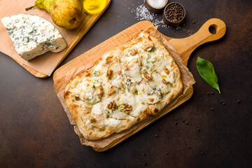 Wall Mural - pizza with pear and Gorgonzola on Roman dough, pinsa on dark brown table top view