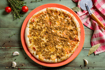 Italian meat pizza with meatballs on green wooden table top view