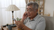 © PRPicturesProduction - Sad old asian man with credit card call bank support by cellphone reporting about money fraud. senior male telling problem on smartphone while taking debit card. elderly grandpa talk on mobile phone