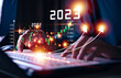 © teerawat - Businessman hand touching and pointing on year 2023 with virtual screen from 2022 to 2023, Businessman plan and increase of positive indicators in his business, Growing up business concepts.