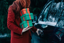 Redhead Woman With Christmas Gifts Standing By Car