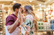 © Westend61 - Affectionate man and woman kissing each other in store