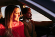 © Westend61 - Couple driving in car with woman looking into sunlight
