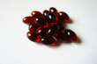 Handful of red softgel capsules of krill oil
