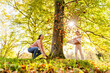 © Westend61 - Happy mother and daughter playing with autumn leaves under tree