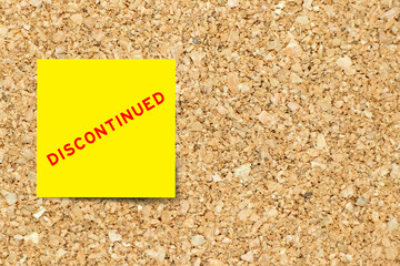 Sticker - Yellow note paper with word discontinued on cork board background with copy space