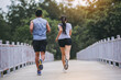 © Panumas - Young couple running together on road across the bridge. Couple, fit runners fitness runners during outdoor workout.