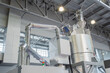 © zyabich - Parts of automatic injection molding machine - dryer heat hopper tank for drying plastic granules at exhibition, trade show. Manufacturing, production, technology concept