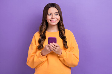 Sticker - Photo of cute positive blogger user wear orange trendy clothes presenting device shop offer sale isolated on purple color background