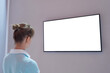 © zyabich - Woman looking at blank digital interactive white display wall at exhibition or museum with futuristic scifi interior. White screen, mock up, future, copyspace, template, technology concept