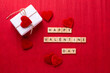Romantic  layout. Box with present with hearts, wooden latters on  red texture paper background.  Place for text. Top view. St. Valentines day postcard.