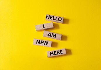 Hello I am new here symbol. Concept words Hello I am new here on wooden blocks. Beautiful yellow background. Business and Hello I am new here concept. Copy space.