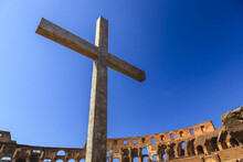 Close-up Of A Christian Cross Inside The Roman Colosseum Against A Blue Sky, Erected By The Pope In 2000 To Commemorate Christian Martyrs; Rome, Lazio, Italy