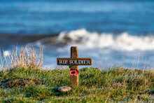 A Small Wooden Cross With A Red Poppy As A Soldier's Memorial By The Ocean; Whitburn, Tyne And Wear, England