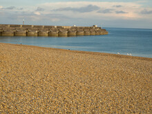 View Of Brighton Beach And Sea Defences Towards The Marina At Sunset; Brighton, East Sussex, England