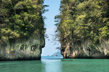 View Of A Yacht Anchored In The Green, Turquoise Colored Waters In Between Too Vast, Karst Rock Formations Creating A Tranquil Scene; Phang Nga Bay, Thailand