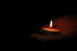 © New Africa - Woman holding burning candle in darkness, closeup. Space for text