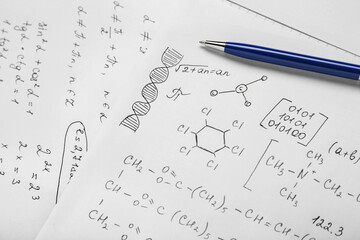 Sheets of paper with different chemical formulas and pen, closeup
