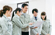 © buritora - ノートパソコンを持って工場・工務店企業で会議する作業着を着た従業員・スタッフの横顔