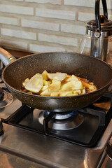 Canvas Print - Frying pan on gas stove on fire with pears in syrup