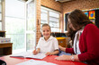 © Austockphoto - Teacher Helping Young Schoolgirl Smiling at the Camera