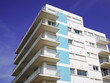 © OceanProd - blue facade white apartment real estate building exterior architecture in blue summer sky