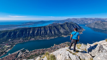 man with panoramic view from pestingrad (derinski vrh) of kotor bay in sunny summer, adriatic medite