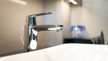 A luxury automatic hand washing faucet with background of . Interior equipment object photo, selective focus.	
