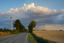 France, Loire-atlantique, Loireauxence, Country Road And Wind Turbine In Field