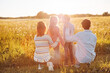 © candy1812 - Family standing on the sunset on the field in natural park.