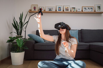 Young Caucasian woman with virtual reality headset, enjoying interacting in computer generating environment