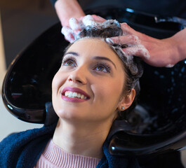 Hairdresser washing hair of the woman in modern hair salon