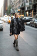 © LIGHTFIELD STUDIOS - full length of blonde woman in black leather jacket and dress catching cab on street in New York