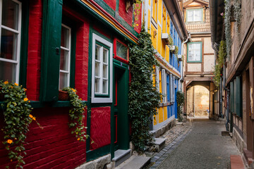 Wall Mural - Quedlinburg, Saxony-Anhalt, Germany, 28 October 2022: Schuhhof or cobbler narrow street, Historic old vintage colored timber frame houses in medieval town, half-timbered home at sunny autumn day