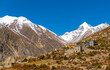 Small himilayan town of Gunsang with huge snowy mountains in the distance. Shot on a sunny cloudless day in the fall.