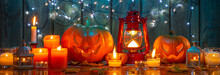 Glowing Halloween Pumpkin, Many Burning Candles And Vintage Lantern On A Wooden Background