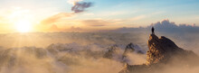 Adventurous Man Hiker Standing On Top Of Icy Peak With Rocky Mountains In Background. Adventure Composite. 3d Rendering Rocks. Aerial Image Of Landscape From BC, Canada. Sunset Sky