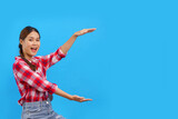 Fototapeta  - Women smiling and holding an object both hands with empty space on isolated light blue background