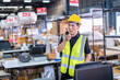 © Tongpool - Worker working in large depot storage warehouse hold radio walkie talkie to team at cashier counter