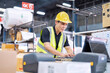 © Tongpool - Worker working in the large depot storage warehouse happy smiling packing box at cashier counter