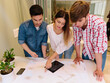 © ADDICTIVE STOCK - Three Architects and engineers working at the Office Checking Blueprints