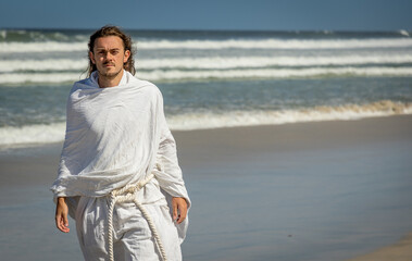 Wall Mural - holy, Jesus-type person walking next to sea in white robe