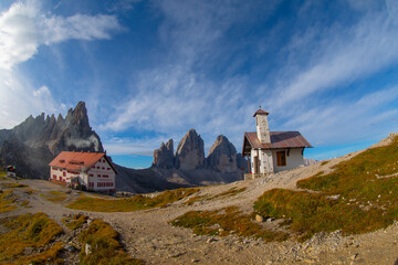 Wall Mural - Mountain valley on a sunny day with clouds. Landscape with a bridge, high rocks, colorful blue sky, clouds, sunlight. Mountains in Tre Cime park in Dolomites, Italy. Italian alps.