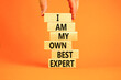 I am my own best expert symbol. Concept words I am my own best expert on wooden blocks on a beautiful orange table orange background. Businessman hand. Business i am my own best expert concept.