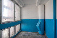 Old Interior Of Staircase With White-blue Painted Walls Of The Multi-apartment, Multistory Building With Big Square Windows And Rubbish Chute Pipe.